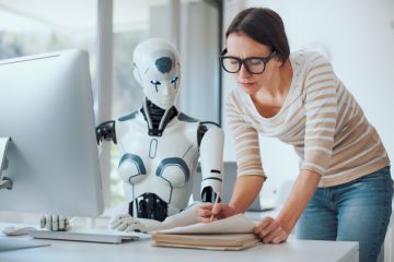A robot helps a female lecturer mark exam scripts
